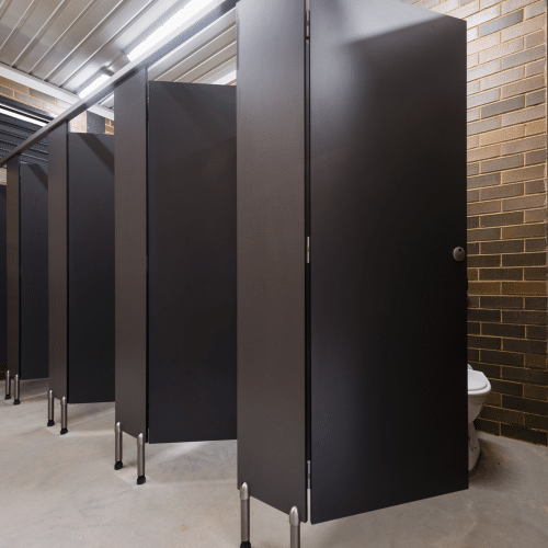 Pedestal-mounted toilet partitions with overhead bracing provide durability in public restrooms.